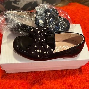 Black shoes with a black bow with white dots.